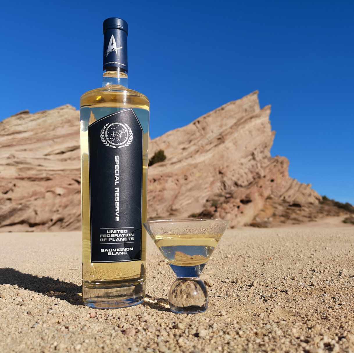White wine bottle and glass in a desert